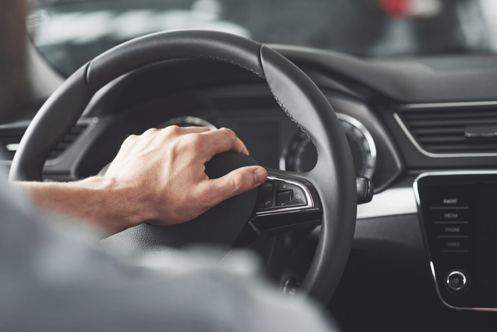 Homem com a mão no volante no carro Homem coma mão no volante enquanto dirige